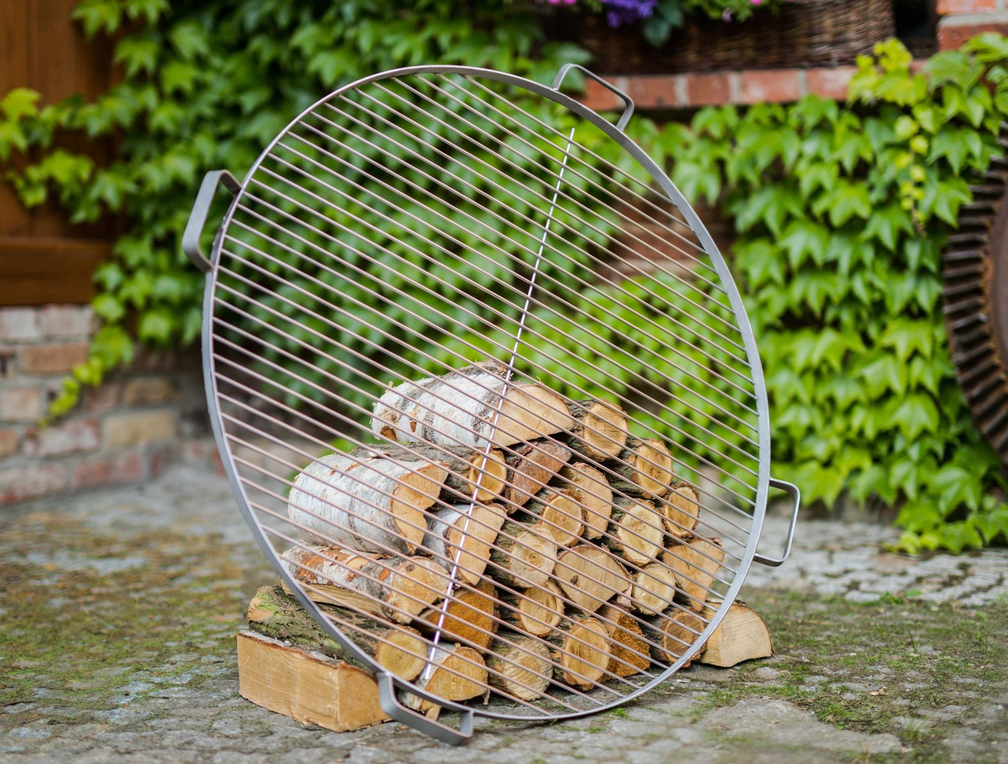 Cook King 60 cm Stainless Steel Grate with 4 Handles For Fire Bowl in an outdoor setting
